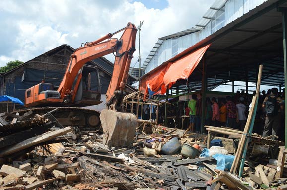 Alat berat membongkar rumah warga di Desa Purwaraja, Kecamatan Menes, kemarin.