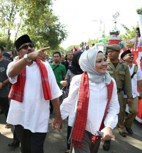 Rano Karno menggandeng Dewi Indriati dalam pawai kemenangan Banten sebagai juara umum MTQ ke-26 Tingkat Nasional. 