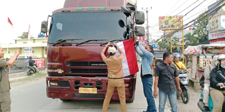 Camat Teluknaga Stop Pengguna Jalan, Bagikan Bendera Merah Putih Sambut HUT RI ke 80