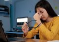 Perempuan mengalami kelelahan mata setelah menggunakan laptop dalam waktu lama