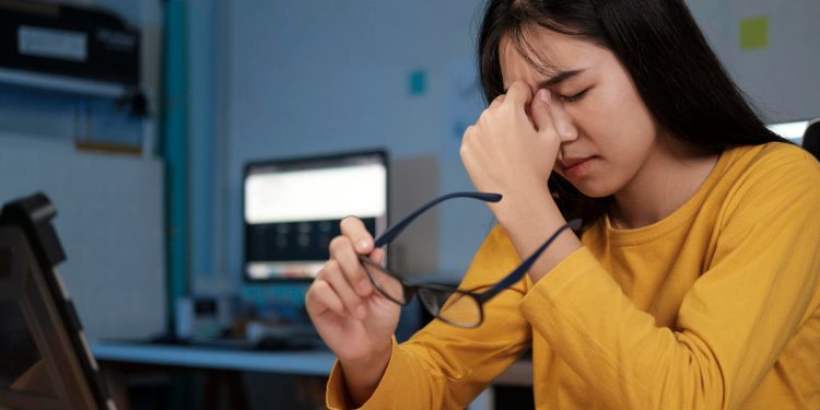 Perempuan mengalami kelelahan mata setelah menggunakan laptop dalam waktu lama